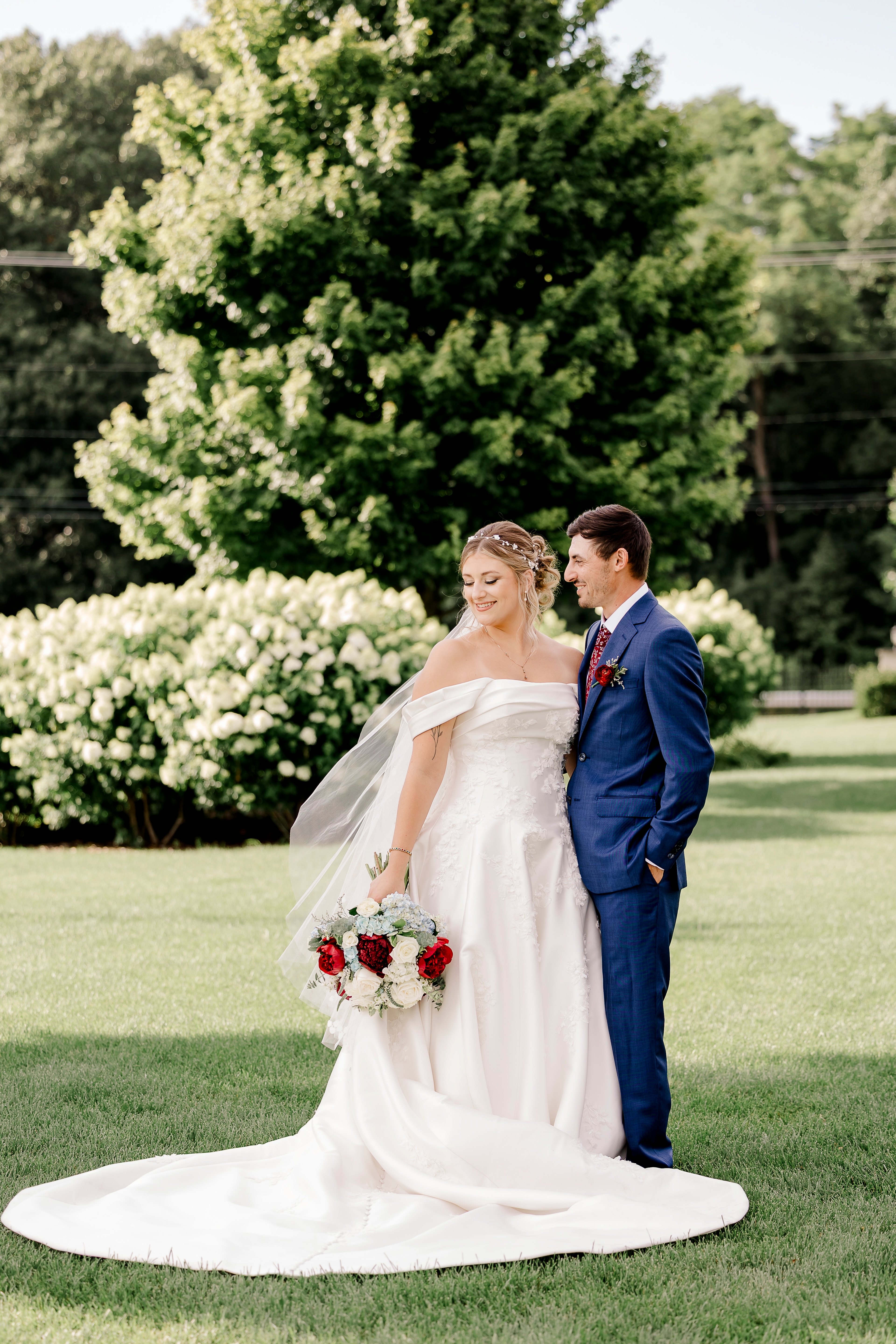A bride and groom standing together on a lawn